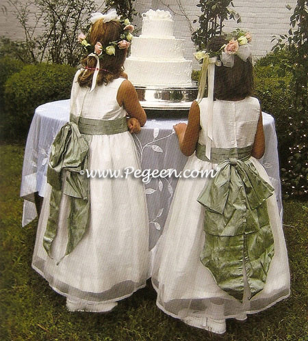 Flower girl dress in antique white and sage green with an organza skirt.