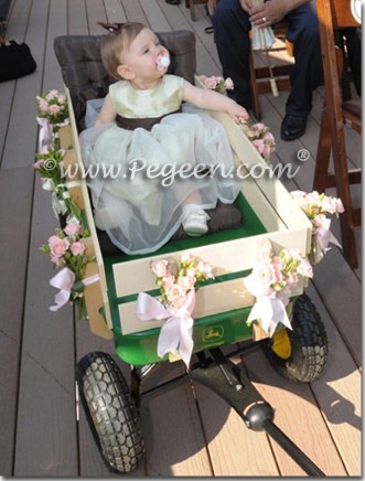flower girl pulling baby in wagon